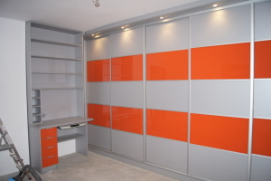 szafa garderobiana z drzwiami przesuwnymi szyba lacobel koloru pomarańczowego połączona z płytą meblową